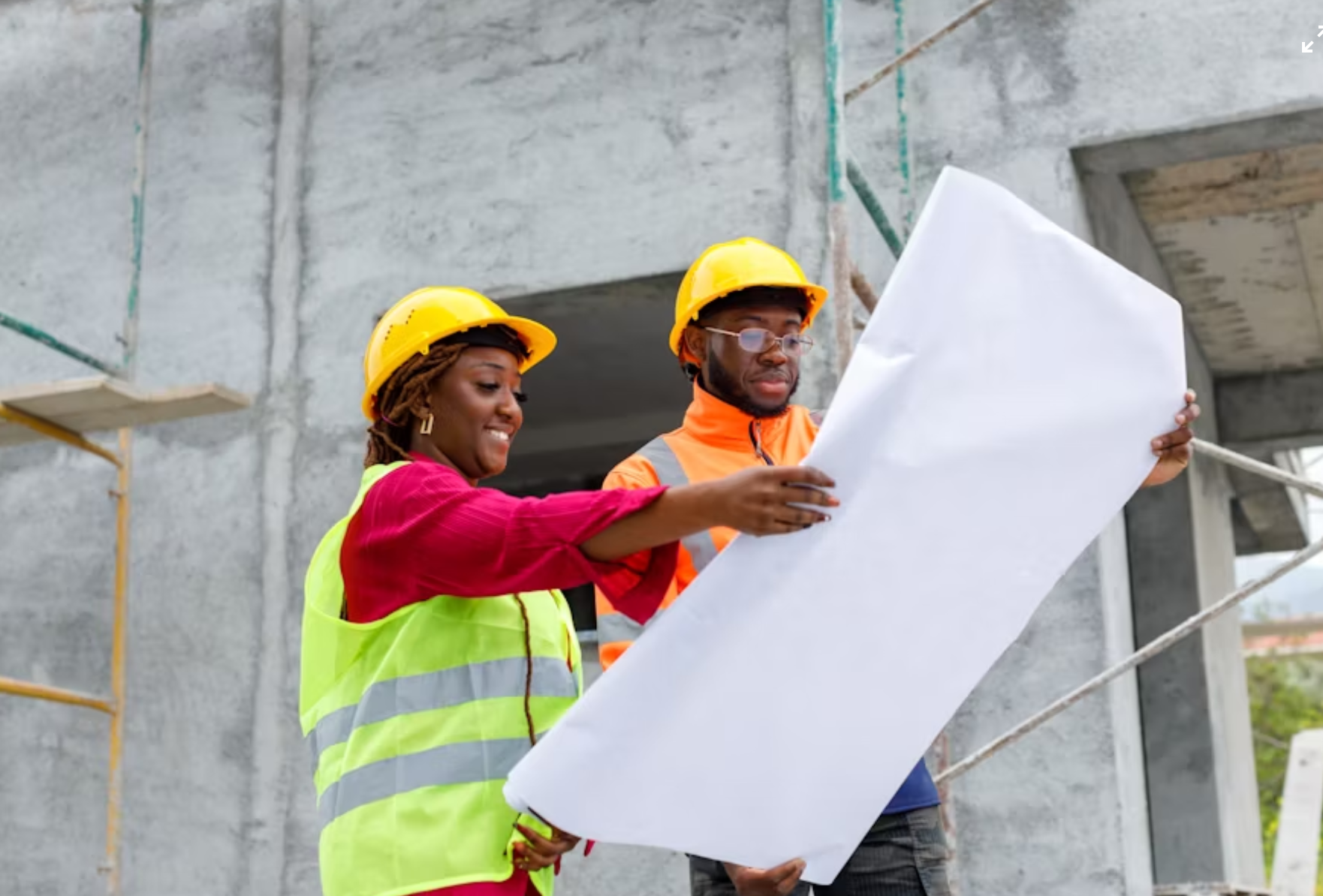 Construction workers reviewing blueprints at a construction site